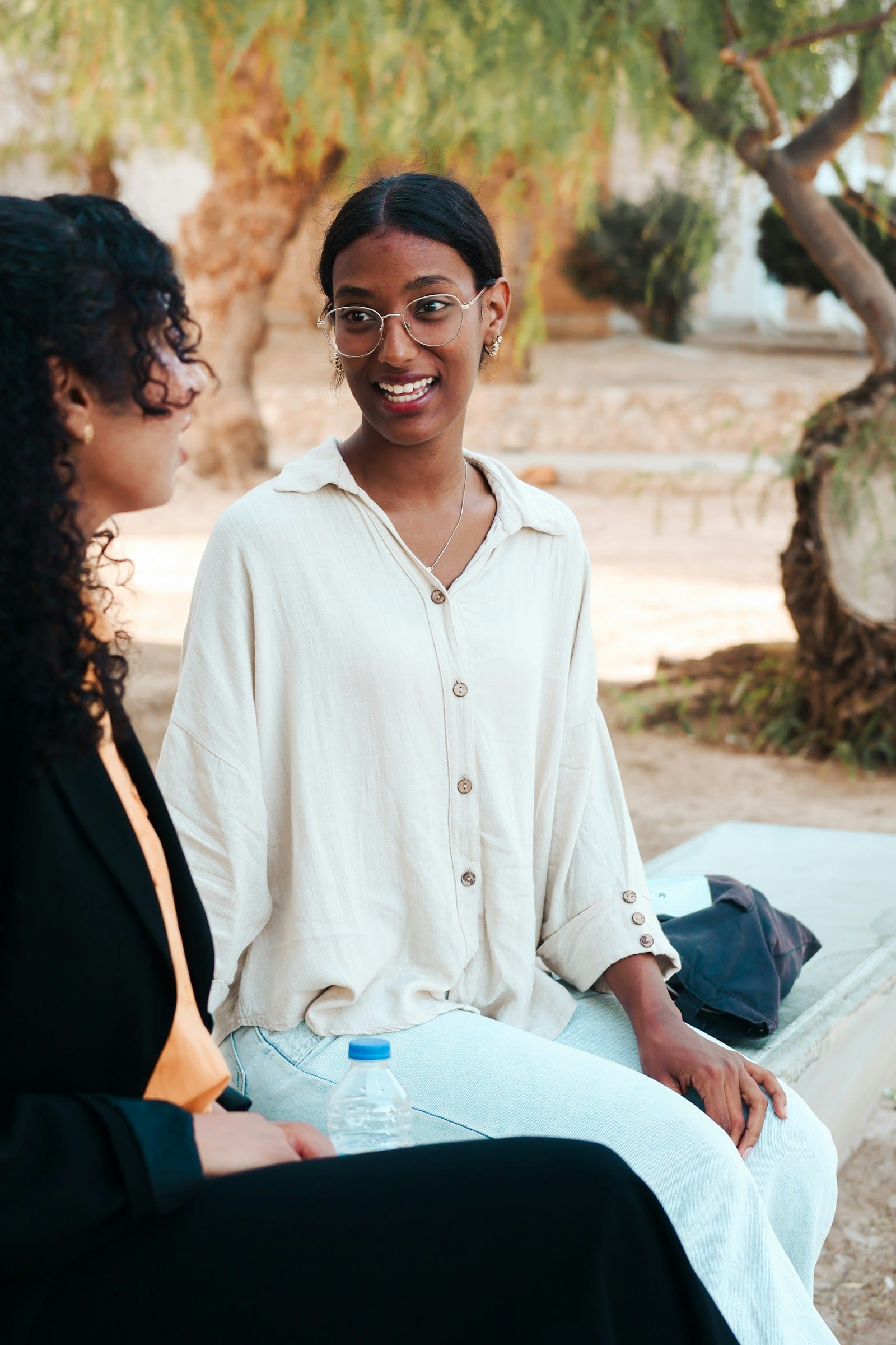 Two women talking while sitting on a bench outdoors