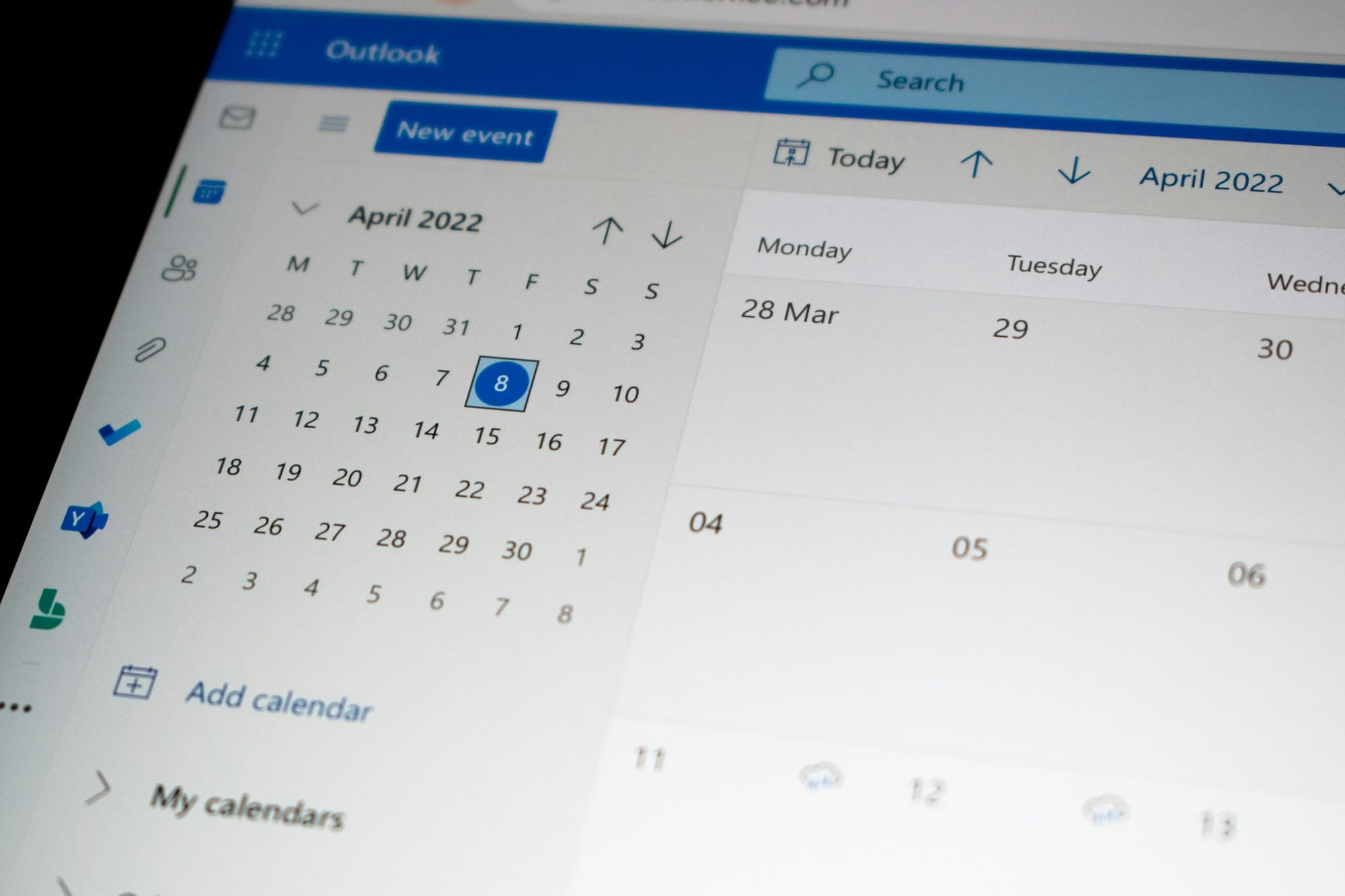 A computer monitor showing Microsoft Outlook’s calendar: an April 2022 month picker with Friday the 8th selected, plus a larger week grid of late March and early April