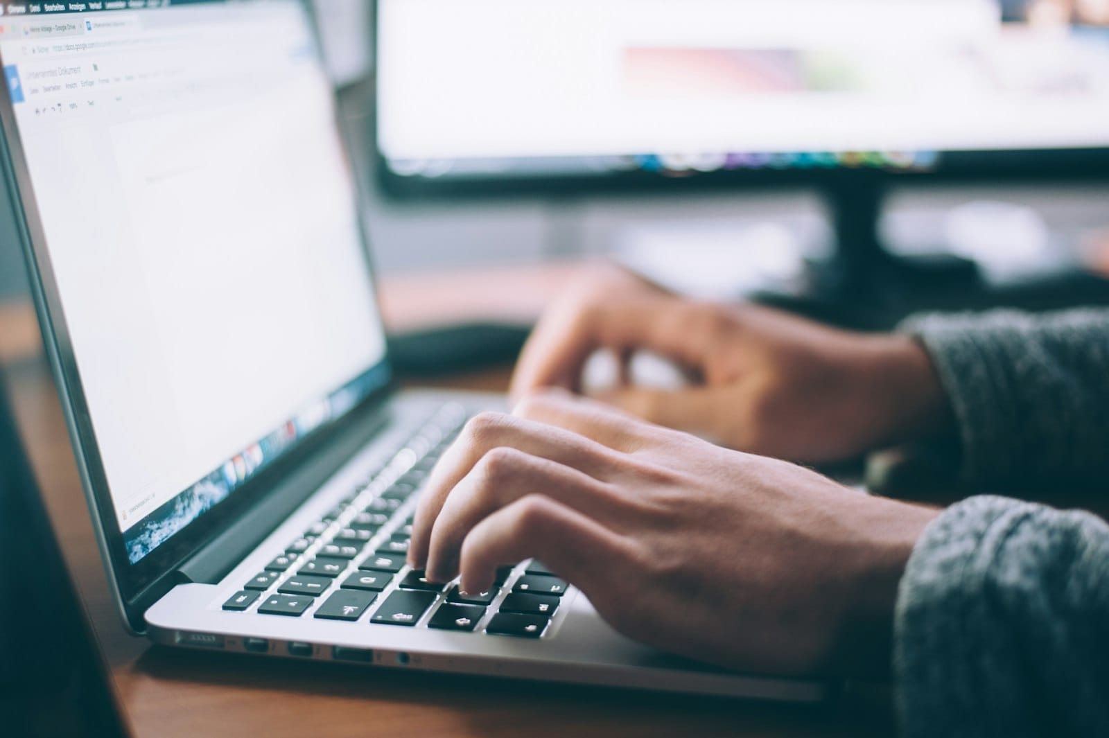 Hands typing on a laptop while searching