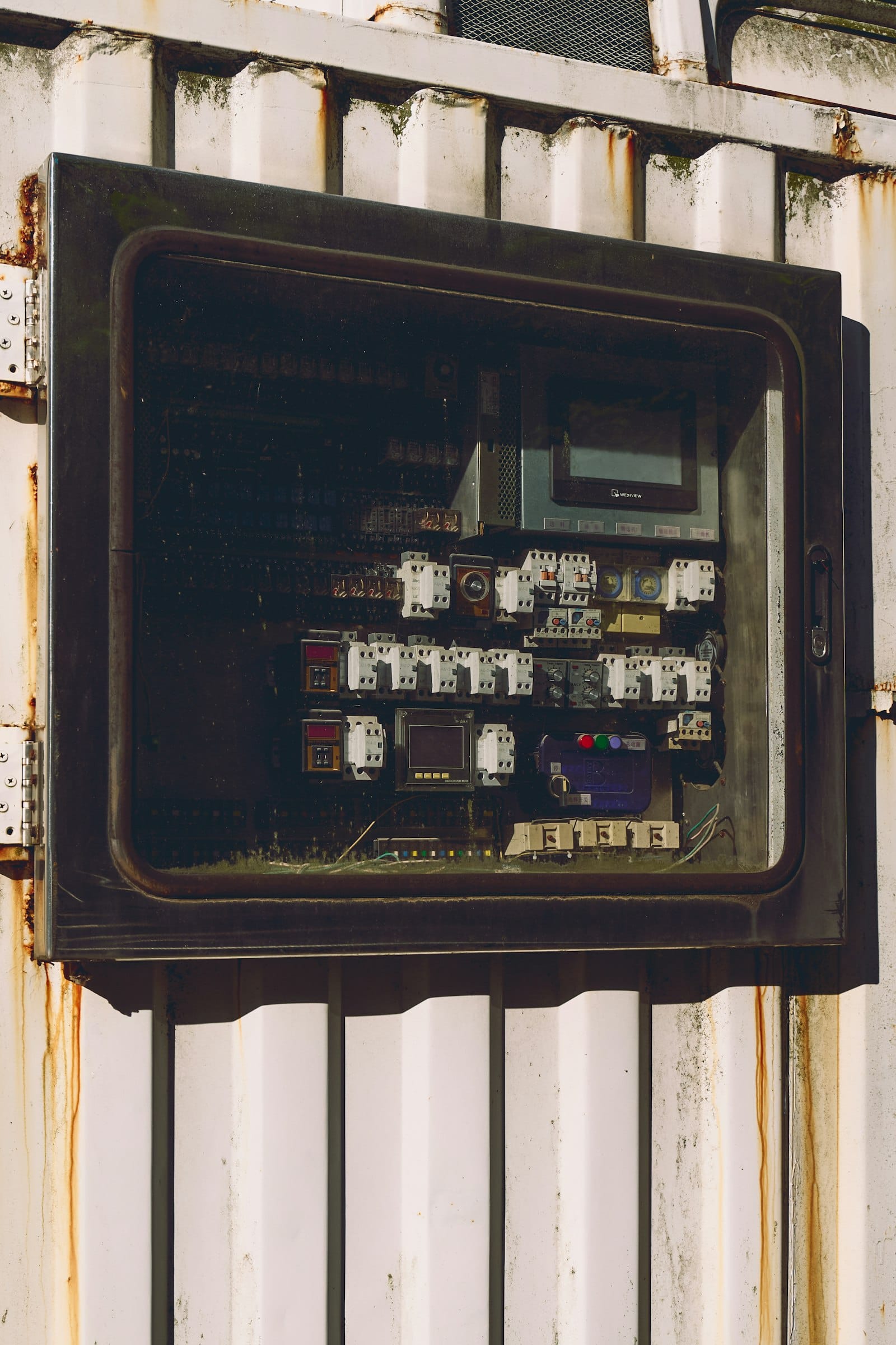 An outdoor electrical panel packed with rows of breakers, buttons, and displays, too many switches at once
