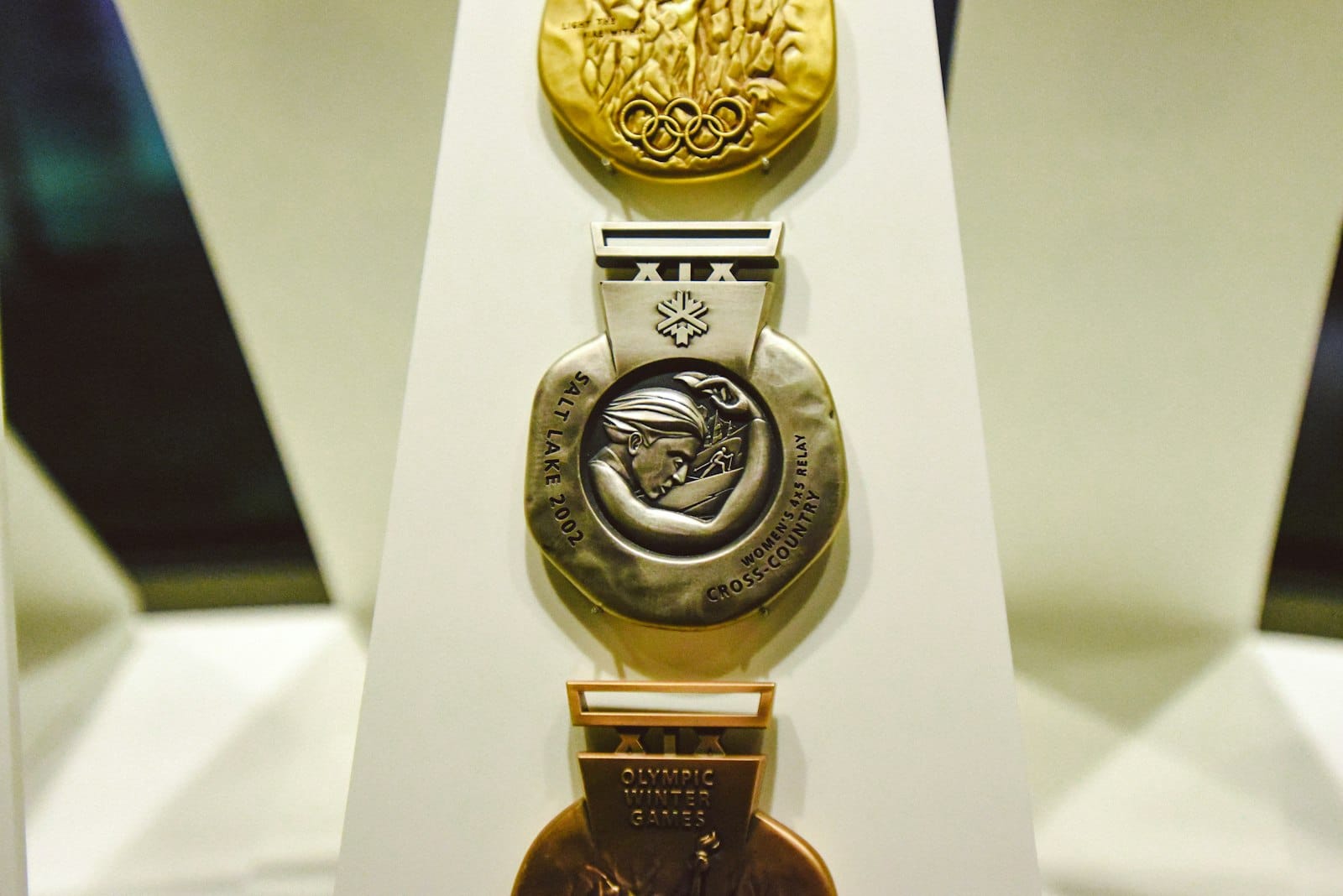 Gold, silver, and bronze Olympic medals on a display stand