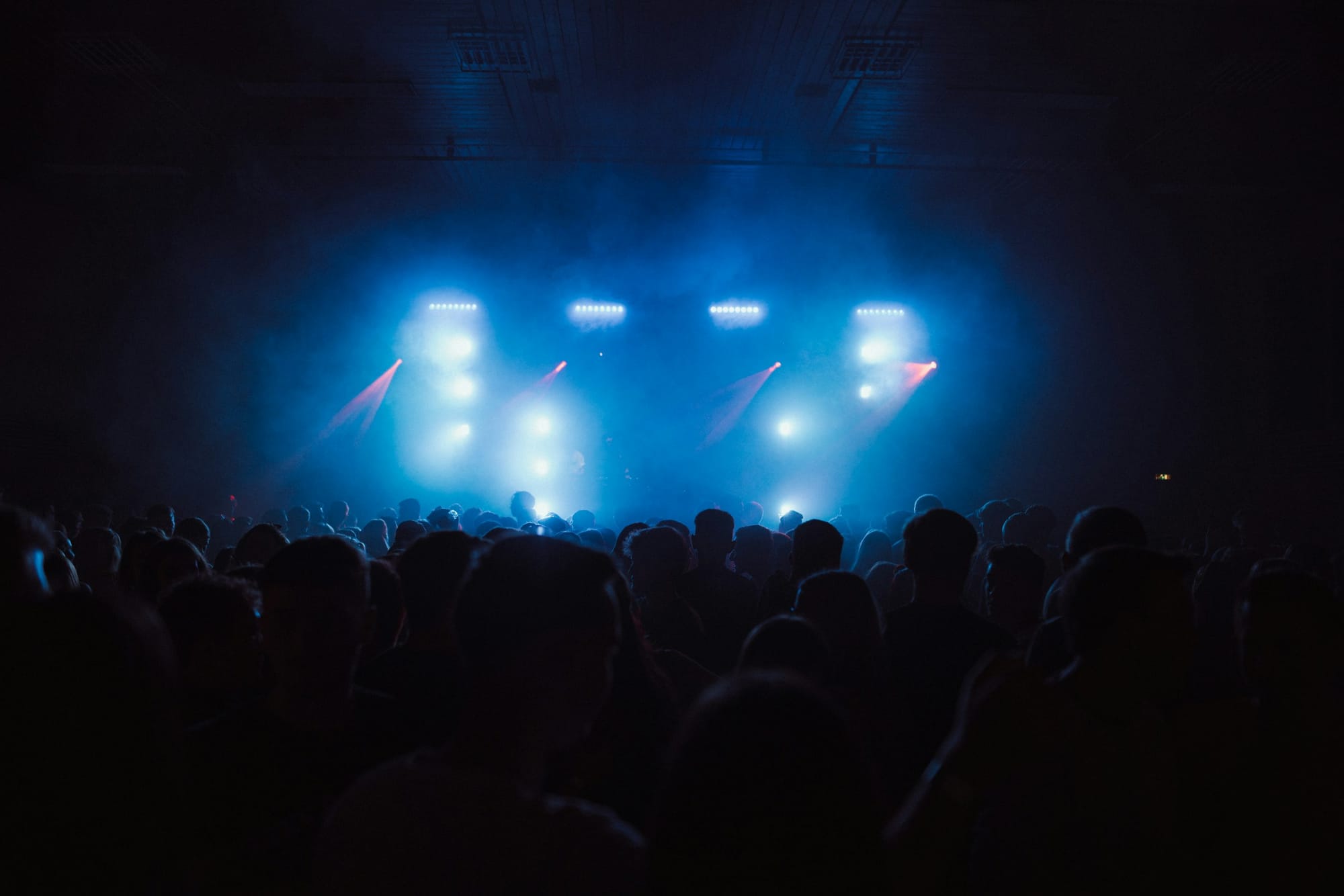 Crowd watching a lit stage performance