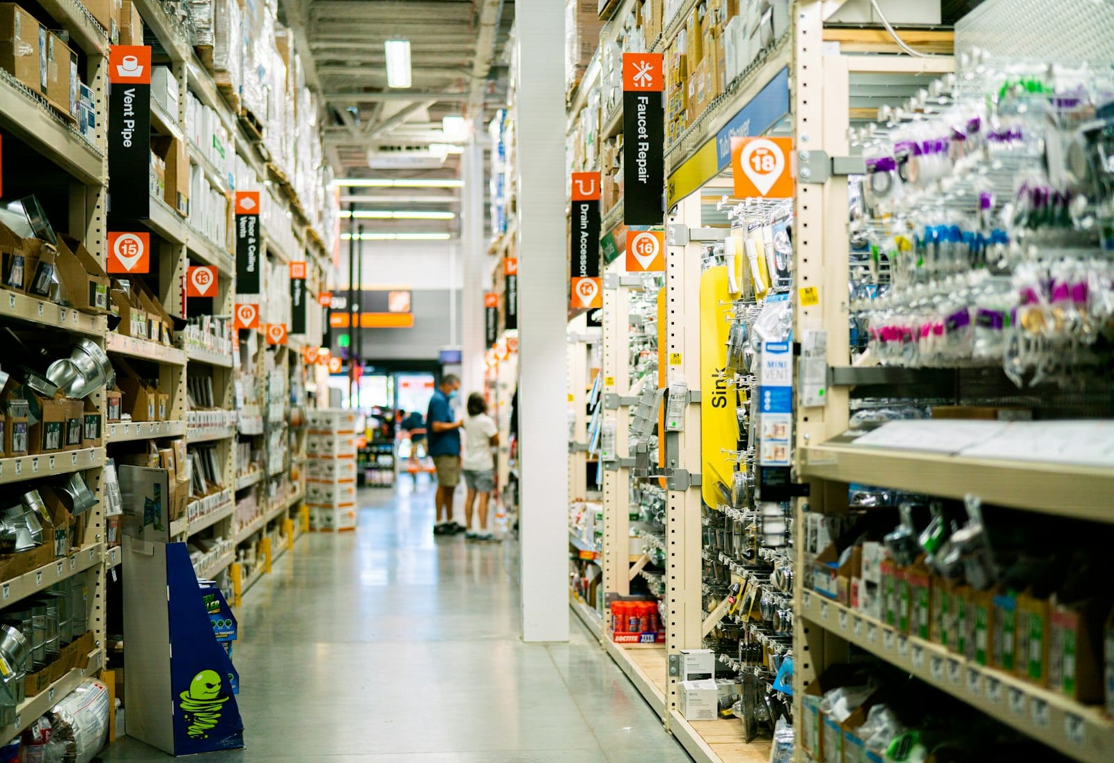 Hardware store aisle lined with labeled shelves for browsing