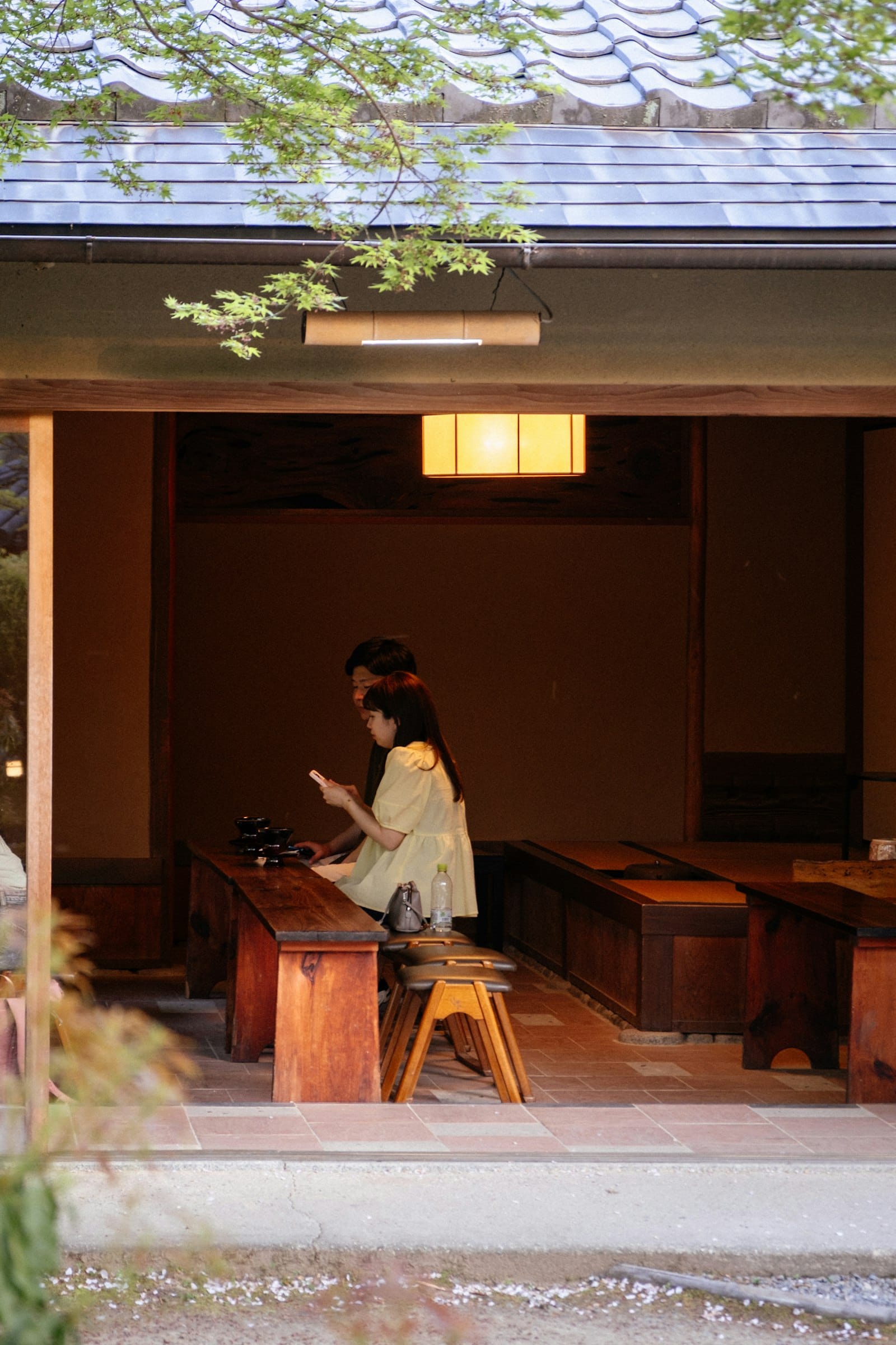 A couple seated indoors at a wooden table in a warm cafe