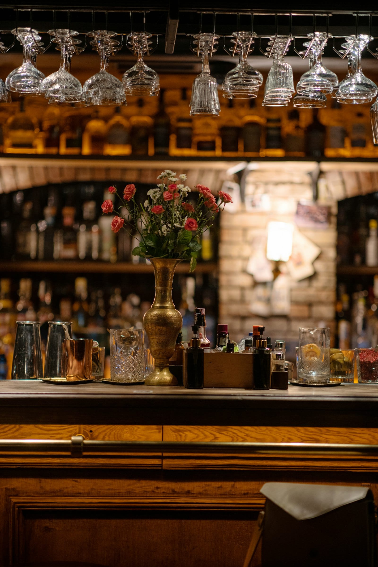 Bar counter with a flower vase, glassware, and cocktail tools
