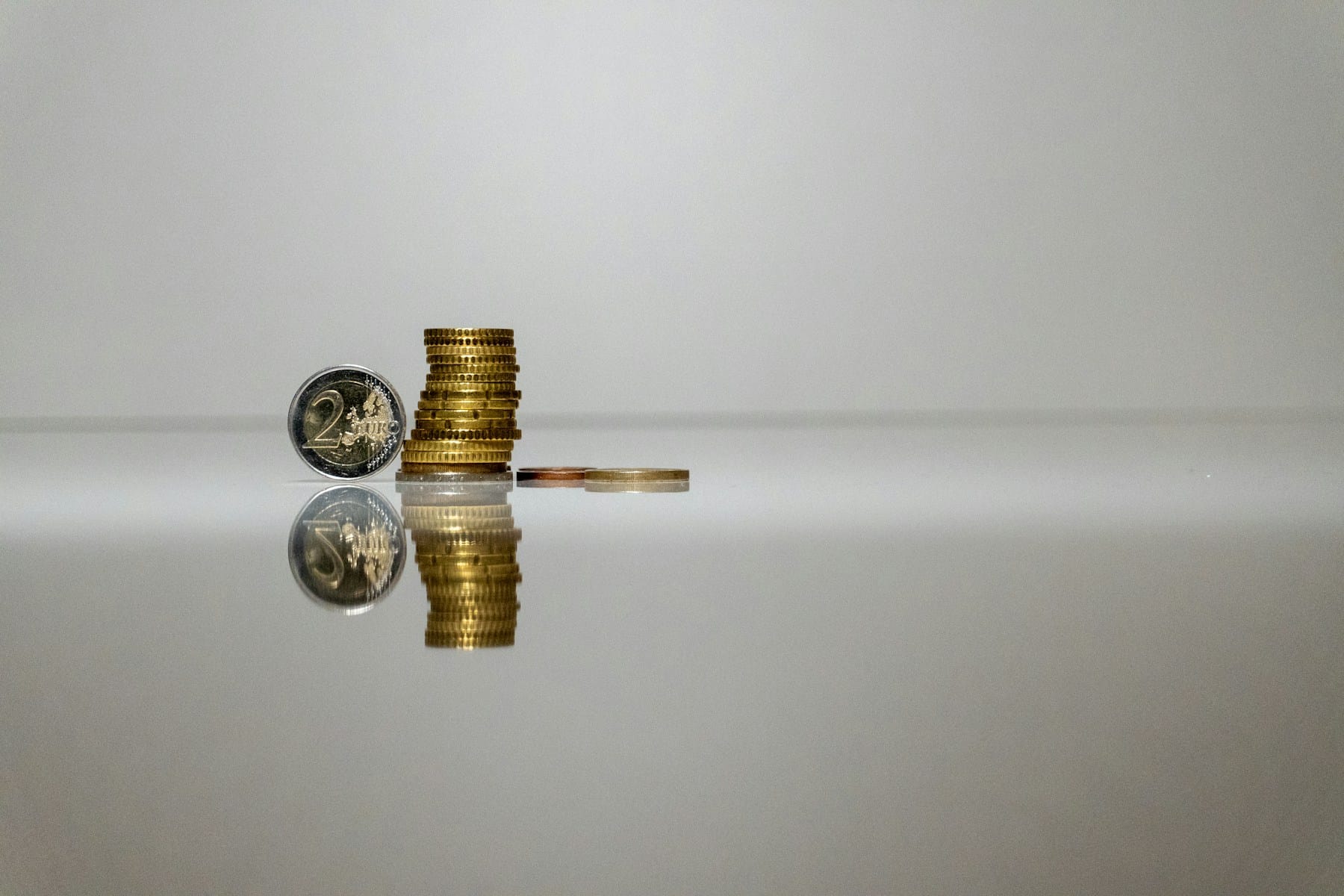 Euro coins stacked on a reflective surface