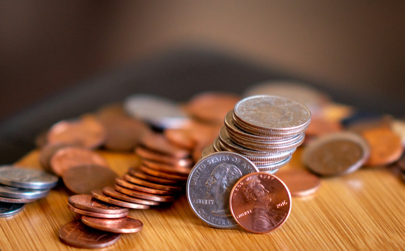 US coins stacked and scattered on a wooden table