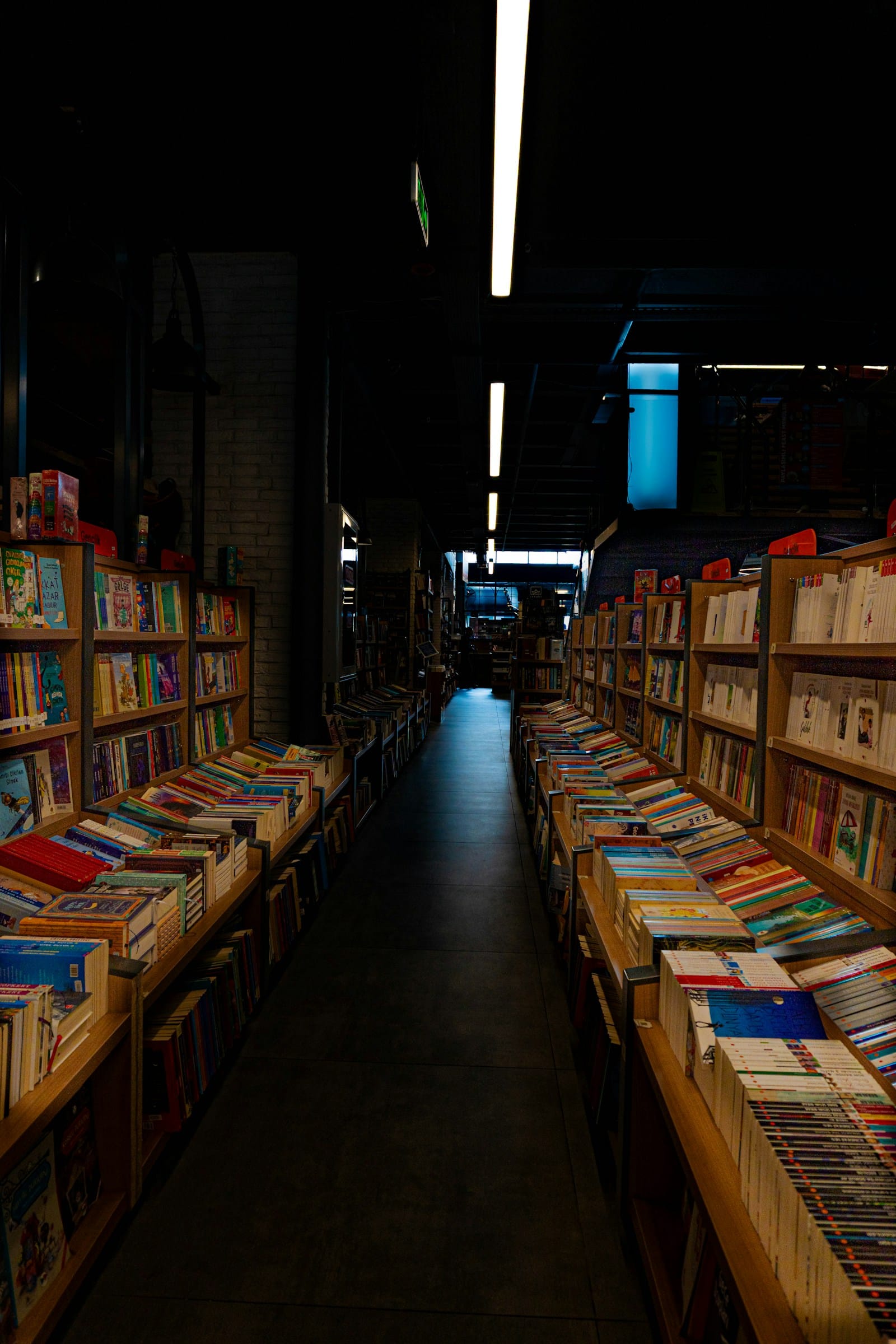 Long bookstore aisle lined with packed shelves