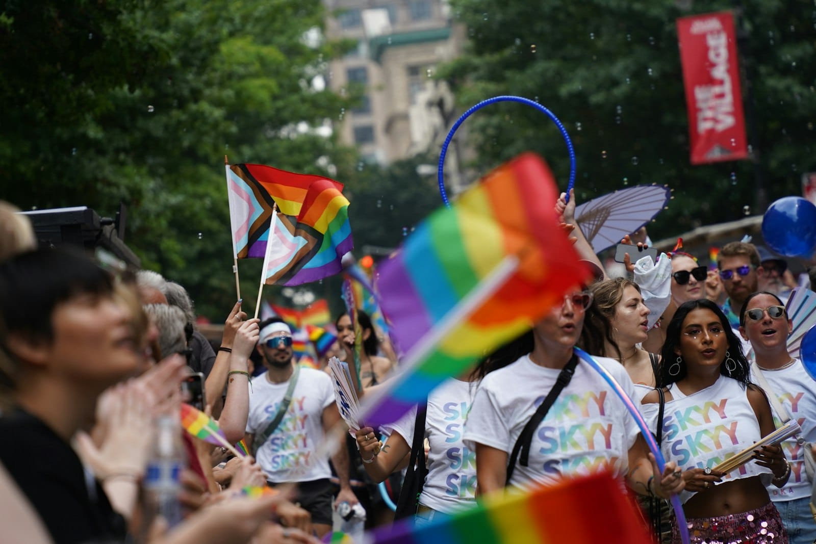 Pride parade crowd with progress flags and rainbow colors