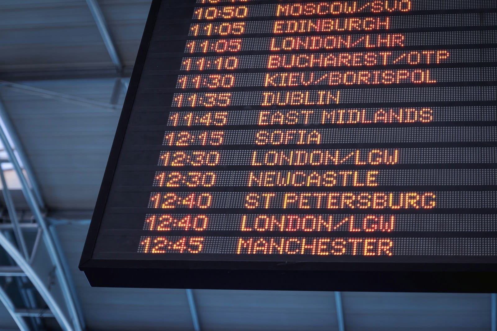 An airport departures board showing rows of times beside destination cities