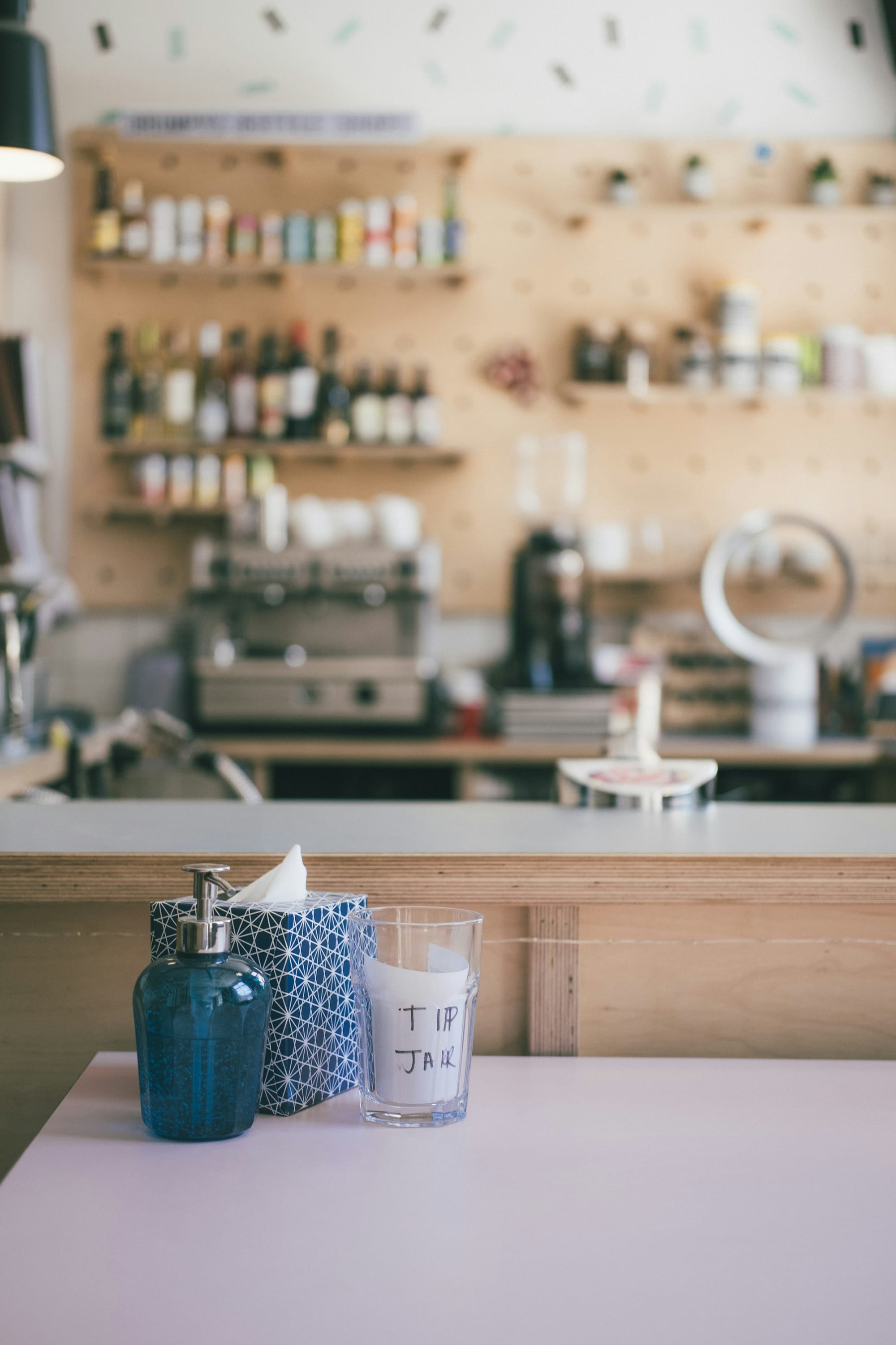 Cafe counter with a clear glass tip jar labeled TIP JAR